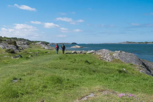 två personer vandrar vid havet