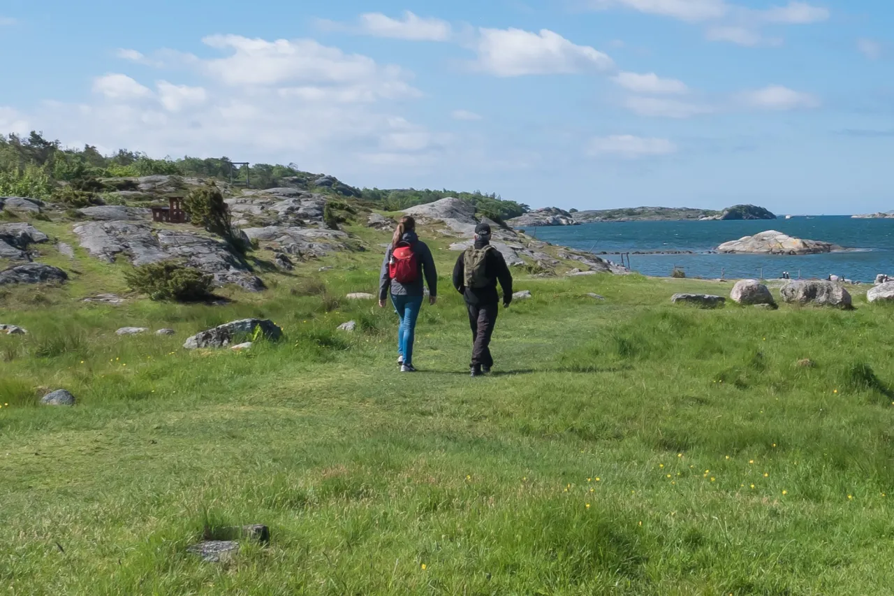 två personer vandrar vid havet